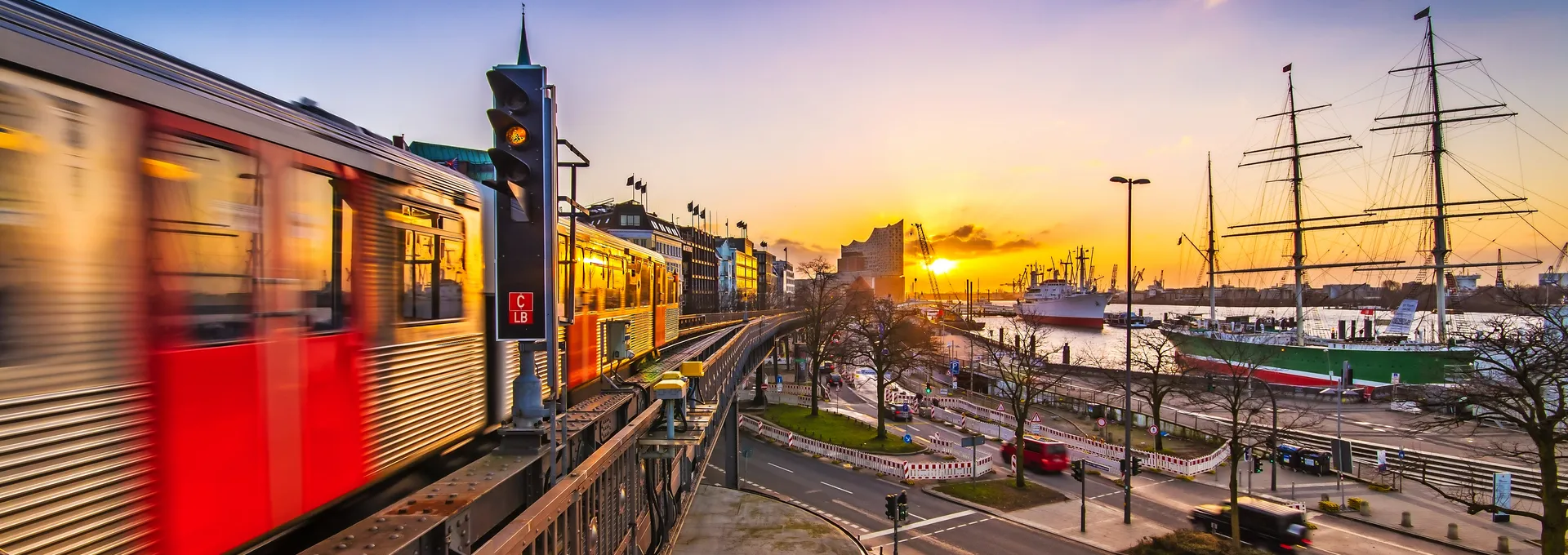 © powell83 - stock.adobe.com Eine U-Bahn fährt bei Sonnenuntergang über eine Brücke in einer Stadt.