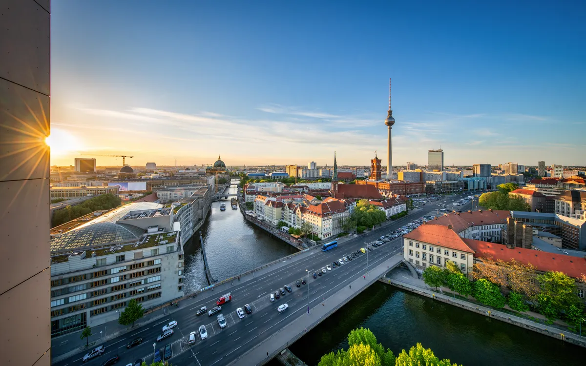Panoramablick auf Berlin mit Fernsehturm und Spree bei Sonnenuntergang.