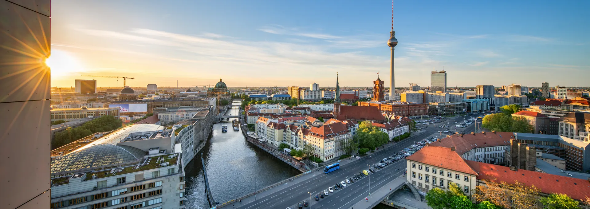 Panoramablick auf Berlin mit Fernsehturm und Spree bei Sonnenuntergang.