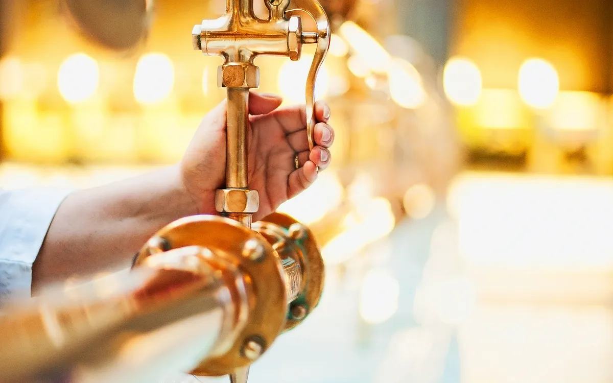Eine Hand füllt ein Glas am Heilwasserausschank.
