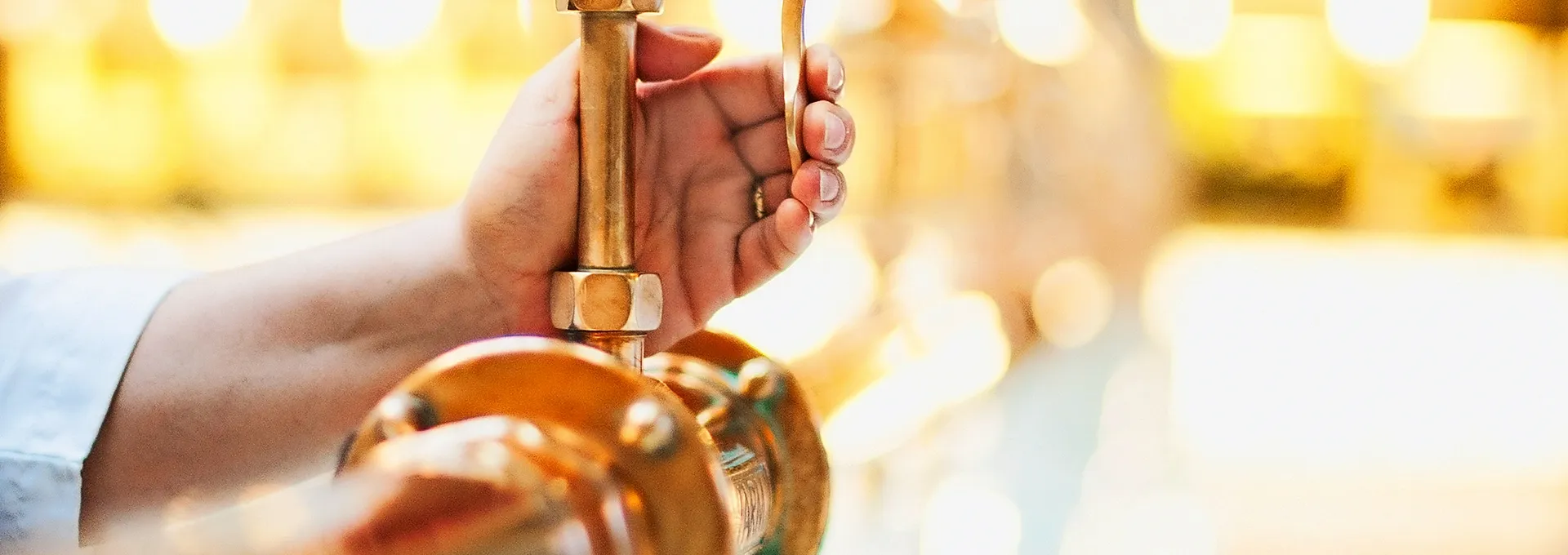 Foto: Heji Shin Eine Hand füllt ein Glas am Heilwasserausschank.
